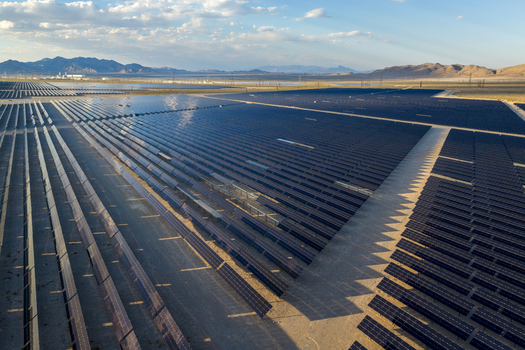 Aerial view of a vast solar panel array stretching across the desert landscape with mountains under a blue sky in Enterprise Nevada United States. Aerial view of a vast solar panel array stretching across the desert landscape with mountains under a blue sky in Enterprise Nevada United States.