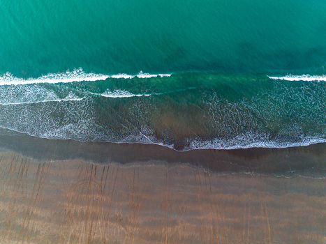 Aerial view of waves crashing onto the sandy shore where the turquoise sea meets the brown land Cox s Bazar Chittagong Division Bangladesh.