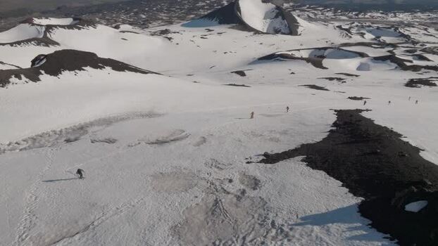 Aerial view of skiers on the snowy slopes of Mount Etna Italy. Aerial view of skiers on the snowy slopes of Mount Etna Italy.