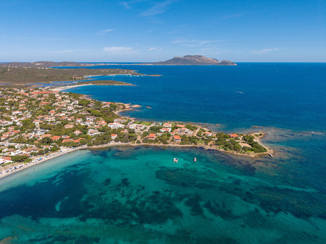 Aerial view of the coastal landscape of Pittulongu with turquoise waters sandy beaches and residential houses surrounded by Mediterranean vegetation in Pittulongu Sardinia Italy.