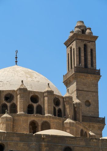 View of Abu Dahab Mosque featuring its historic stone dome and square minaret under a clear blue sky in El Darb El Ahmar Cairo Governorate Egypt. View of Abu Dahab Mosque featuring its historic stone dome and square minaret under a clear blue sky in El Darb El Ahmar Cairo Governorate Egypt.