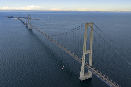 Aerial view of the Great Belt Bridge with its massive concrete pylons and suspension cables stretching across the blue sea under a clear sky Denmark. Aerial view of the Great Belt Bridge with its massive concrete pylons and suspension cables stretching across the blue sea under a clear sky Denmark.