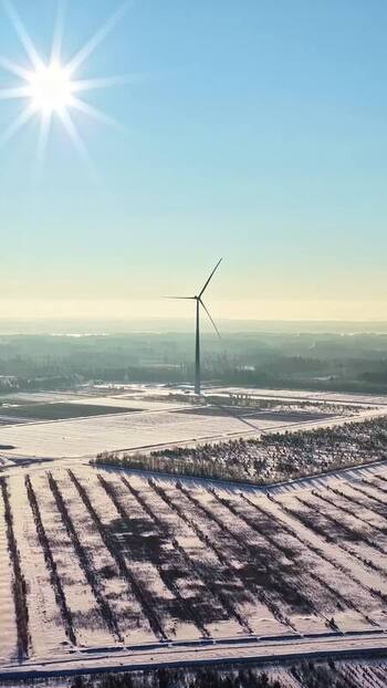 Aerial view of wind turbine in snowy landscape Latvia.