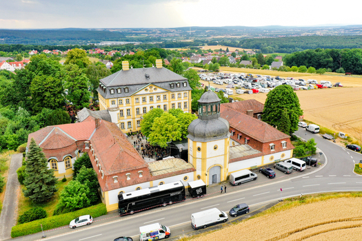 Aerial view of Schloss Jagersburg featuring its historic architecture courtyard with people and surrounding green trees and fields in Eggolsheim Bayern Germany. Aerial view of Schloss Jagersburg featuring its historic architecture courtyard with people and surrounding green trees and fields in Eggolsheim Bayern Germany.