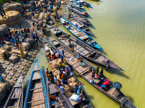 Islampur Bangladesh 05 September 2025 Aerial view of people loading large bundles of jute onto traditional wooden boats along the riverbank. Islampur Bangladesh 05 September 2025 Aerial view of people loading large bundles of jute onto traditional wooden boats along the riverbank.