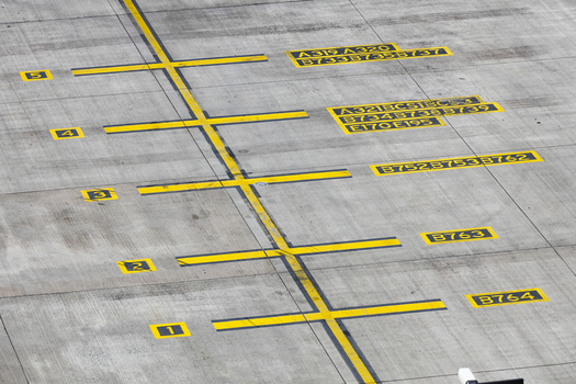 View of yellow ground markings for aircraft parking positions on the concrete tarmac at Berlin Brandenburg Airport BER Berlin Brandenburg Germany.