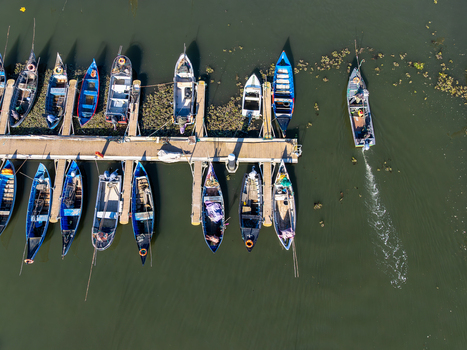 Aerial view of a marina filled with fishing boats casting long shadows on the dark green water Lagos Portugal. Aerial view of a marina filled with fishing boats casting long shadows on the dark green water Lagos Portugal.