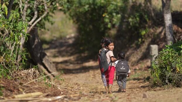 View of children walking on a dirt path in a rural area Nepal.