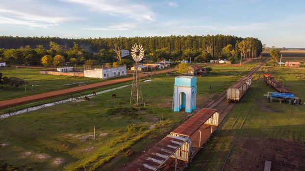 Aerial view of the rural town of Guaviravi featuring a railway line with old train cars a windmill and a water tower set amidst green fields in Guaviravi Corrientes Province Argentina. Aerial view of the rural town of Guaviravi featuring a railway line with old train cars a windmill and a water tower set amidst green fields in Guaviravi Corrientes Province Argentina.