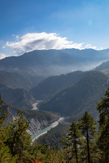 Aerial view of the Swiss Alps near Airolo featuring a winding river through a deep valley lush pine forests and rugged mountain slopes in Airolo Ticino Switzerland. Aerial view of the Swiss Alps near Airolo featuring a winding river through a deep valley lush pine forests and rugged mountain slopes in Airolo Ticino Switzerland.