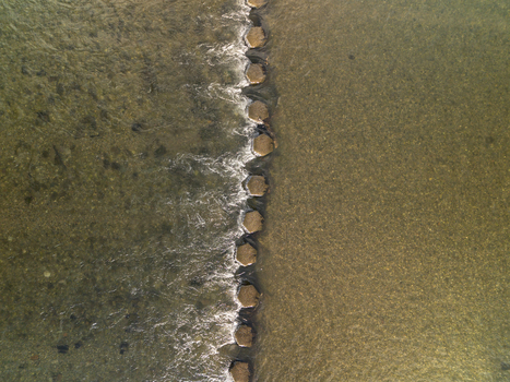 Aerial view of stepping stones crossing the river Lerryn with clear water flowing around the rocks in Lerryn Cornwall United Kingdom. Aerial view of stepping stones crossing the river Lerryn with clear water flowing around the rocks in Lerryn Cornwall United Kingdom.