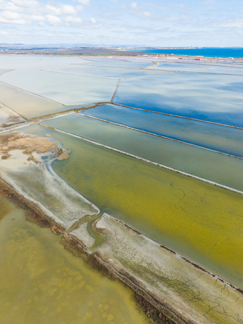 Aerial view of the colorful salt pans of Lake Atanasovsko featuring geometric evaporation ponds and the Black Sea coast under a cloudy sky Burgas Burgas Bulgaria. Aerial view of the colorful salt pans of Lake Atanasovsko featuring geometric evaporation ponds and the Black Sea coast under a cloudy sky Burgas Burgas Bulgaria.