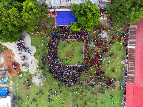 Nilphamari Bangladesh 01 May 2026 Aerial view of a large crowd of people gathered around a square arena on a green field surrounded by trees and buildings. Nilphamari Bangladesh 01 May 2026 Aerial view of a large crowd of people gathered around a square arena on a green field surrounded by trees and buildings.