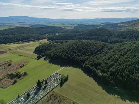 Aerial view of a patchwork of green fields and dark forests meet under a vast sky near a somber cemetery Klastor pod Znievom Slovakia. Aerial view of a patchwork of green fields and dark forests meet under a vast sky near a somber cemetery Klastor pod Znievom Slovakia.
