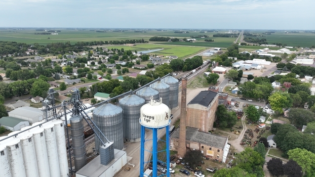 Aerial view of towering grain elevators casting shadows on the landscape with a water tower punctuating the skyline Grenora United States.