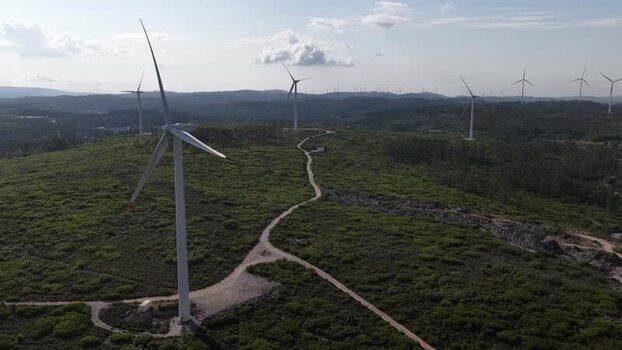 Aerial view of wind turbines on green hills in Portugal. Aerial view of wind turbines on green hills in Portugal.