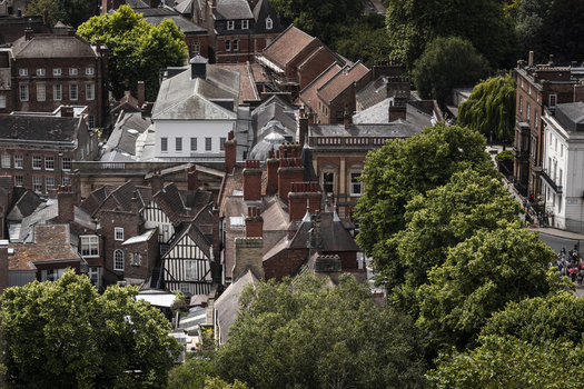 Aerial view of the historic city center of York featuring traditional brick rooftops timber framed buildings and lush green trees in York England United Kingdom.