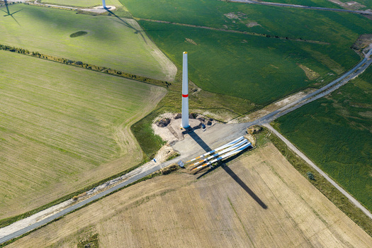 Aerial view of a wind turbine under construction with blades on the ground at Windpark Forst Briesnig II in a recultivated former open pit mine in Forst Brandenburg Germany. Aerial view of a wind turbine under construction with blades on the ground at Windpark Forst Briesnig II in a recultivated former open pit mine in Forst Brandenburg Germany.