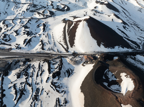Aerial view of the snow covered volcanic craters and dark lava fields on the southern side of Mount Etna in Nicolosi Sicilia Italy. Aerial view of the snow covered volcanic craters and dark lava fields on the southern side of Mount Etna in Nicolosi Sicilia Italy.