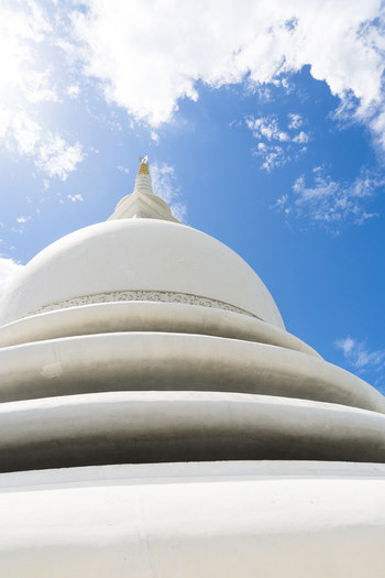 View of the Japanese Peace Pagoda Rumassala showing the white stupa dome against a bright blue sky in Unawatuna Southern Province Sri Lanka. View of the Japanese Peace Pagoda Rumassala showing the white stupa dome against a bright blue sky in Unawatuna Southern Province Sri Lanka.