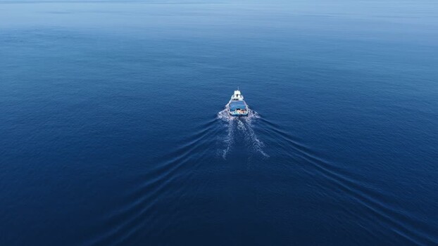 Aerial view of a boat cruising on the deep blue sea Maldives. Aerial view of a boat cruising on the deep blue sea Maldives.