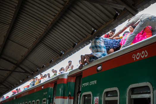 Dhaka Bangladesh 14 June 2018 View of people climbing onto the roof of a crowded train at Airport Railway Station during a busy travel period. Dhaka Bangladesh 14 June 2018 View of people climbing onto the roof of a crowded train at Airport Railway Station during a busy travel period.