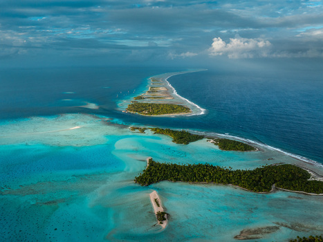 Aerial view of tropical motus and turquoise lagoons surrounded by coral reefs and the deep blue Pacific Ocean in Moorea Maiao Windward Islands French Polynesia. Aerial view of tropical motus and turquoise lagoons surrounded by coral reefs and the deep blue Pacific Ocean in Moorea Maiao Windward Islands French Polynesia.
