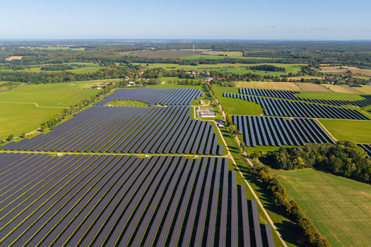 Aerial view of a large solar farm with rows of photovoltaic panels set in green fields and surrounded by trees in Pomeranian Voivodeship Poland. Aerial view of a large solar farm with rows of photovoltaic panels set in green fields and surrounded by trees in Pomeranian Voivodeship Poland.