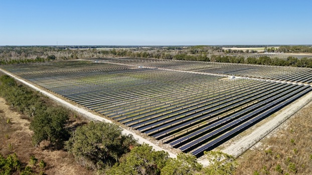 Aerial view of rows of solar panels glinting under the bright sun contrasting with the surrounding dry golden fields Elkton Florida United States. Aerial view of rows of solar panels glinting under the bright sun contrasting with the surrounding dry golden fields Elkton Florida United States.