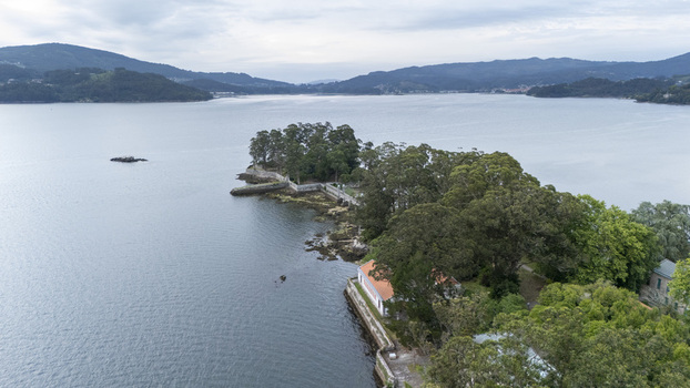 Aerial view of Illa de San Simon featuring historic stone walls and lush green trees surrounded by the calm waters of the estuary Pontevedra Pontevedra Spain. Aerial view of Illa de San Simon featuring historic stone walls and lush green trees surrounded by the calm waters of the estuary Pontevedra Pontevedra Spain.