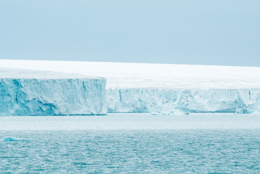 Svalbard and Jan Mayen 26 July 2025 View of a massive blue glacier wall meeting the arctic sea under an overcast sky. Svalbard and Jan Mayen 26 July 2025 View of a massive blue glacier wall meeting the arctic sea under an overcast sky.