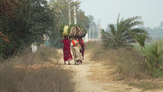 View of women carrying produce on a rural path in Patna India.