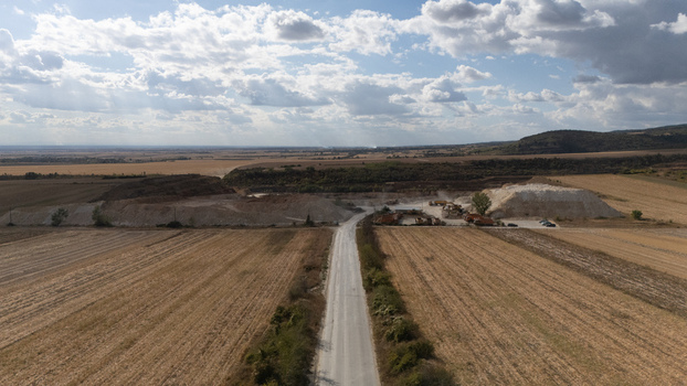 Aerial view of the Besenovo quarry with heavy machinery piles of excavated material and a road leading through agricultural fields in Besenovo Vojvodina Serbia. Aerial view of the Besenovo quarry with heavy machinery piles of excavated material and a road leading through agricultural fields in Besenovo Vojvodina Serbia.