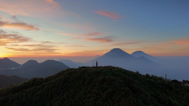 Aerial view of a person on a mountain ridge in Indonesia.