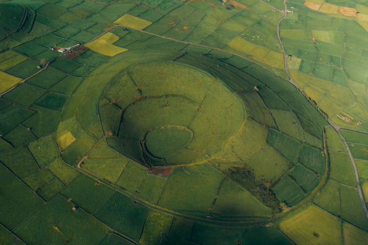 Aerial view of the Pico Dona Joana geodesico volcanic crater surrounded by a patchwork of green fields and stone walls in Feteira Acores Portugal.