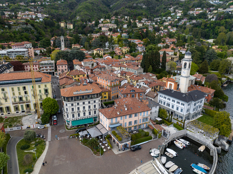 Aerial view of the historic town center featuring the San Vincenzo church tower colorful buildings and a small harbor on Lake Como Cernobbio Lombardia Italy. Aerial view of the historic town center featuring the San Vincenzo church tower colorful buildings and a small harbor on Lake Como Cernobbio Lombardia Italy.