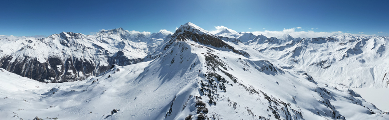 Aerial view of jagged snow covered peaks under a clear blue sky a pristine winter wonderland at Arete de Sorebois Anniviers Valais Switzerland.
