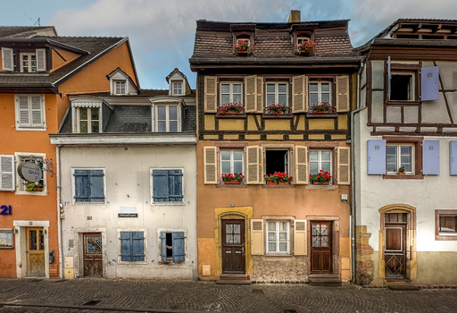 View of colorful half timbered houses with flower boxes and wooden shutters in the historic town center of Colmar Grand Est France.