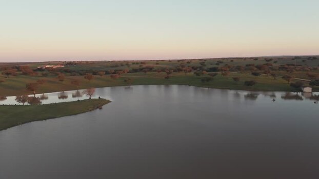 Aerial view of a calm lake and rolling green hills at sunset Portugal. Aerial view of a calm lake and rolling green hills at sunset Portugal.
