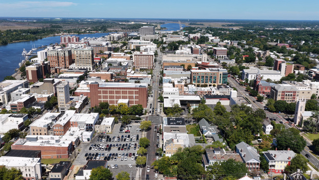 Aerial view of the historic downtown Wilmington cityscape featuring the Cape Fear River urban buildings parking lots and trees in Wilmington North Carolina United States.