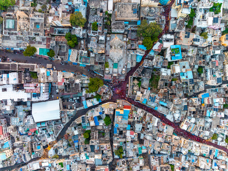 Aerial view of the dense urban fabric of Udaipur featuring traditional rooftops narrow winding streets and historic architecture in Udaipur Rajasthan India.