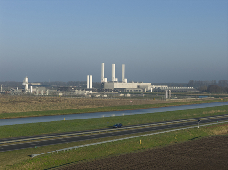 Aerial view of the Nitrogen plant with tall white chimneys industrial buildings and a nearby canal under a clear blue sky in Zuidbroek Groningen Netherlands. Aerial view of the Nitrogen plant with tall white chimneys industrial buildings and a nearby canal under a clear blue sky in Zuidbroek Groningen Netherlands.