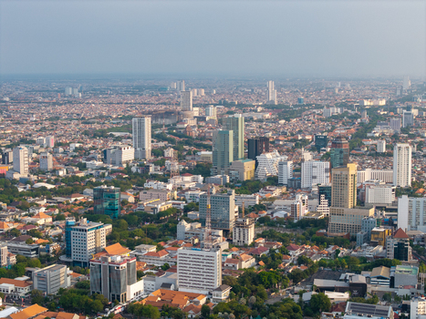 Surabaya East Java Indonesia 28 August 2026 Aerial view of the sprawling cityscape of Surabaya featuring a dense mix of high rise buildings residential areas and trees.