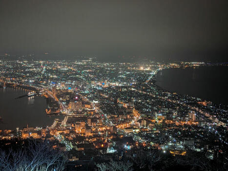 View of the illuminated cityscape of Hakodate at night featuring the harbor and coastal lights as seen from Mount Hakodate Hakodate Hokkaido Japan.