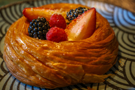 View of a flaky pastry topped with fresh strawberries raspberries and blackberries on a patterned plate at Ruba s Bakery Bistro in San Jose del Cabo Baja California Sur Mexico.