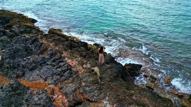 Aerial view of woman on rocky cliffs in Crete Greece.