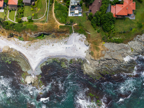 Aerial view of The Clam beach featuring a sandy cove rocky shoreline and luxury villas with red tiled roofs along the coast in Lozenets Burgas Bulgaria. Aerial view of The Clam beach featuring a sandy cove rocky shoreline and luxury villas with red tiled roofs along the coast in Lozenets Burgas Bulgaria.