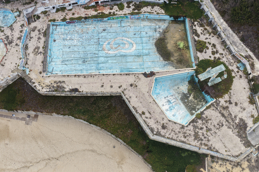 Aerial view of the abandoned swimming pool complex at Praia de Sao Pedro de Moel with graffiti and empty basins overlooking the beach in Marinha Grande Leiria Portugal. Aerial view of the abandoned swimming pool complex at Praia de Sao Pedro de Moel with graffiti and empty basins overlooking the beach in Marinha Grande Leiria Portugal.