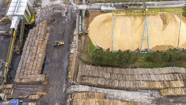 Aerial view of Biofabrica de Ence with large stacks of timber logs and piles of wood chips under industrial cranes in Pontevedra Pontevedra Spain. Aerial view of Biofabrica de Ence with large stacks of timber logs and piles of wood chips under industrial cranes in Pontevedra Pontevedra Spain.