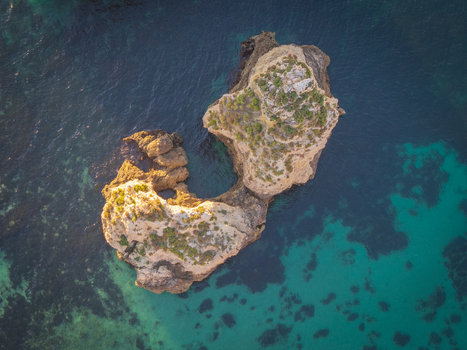 Aerial view of the rugged rock formations and turquoise waters of the coastline near Lagos Faro District Portugal.